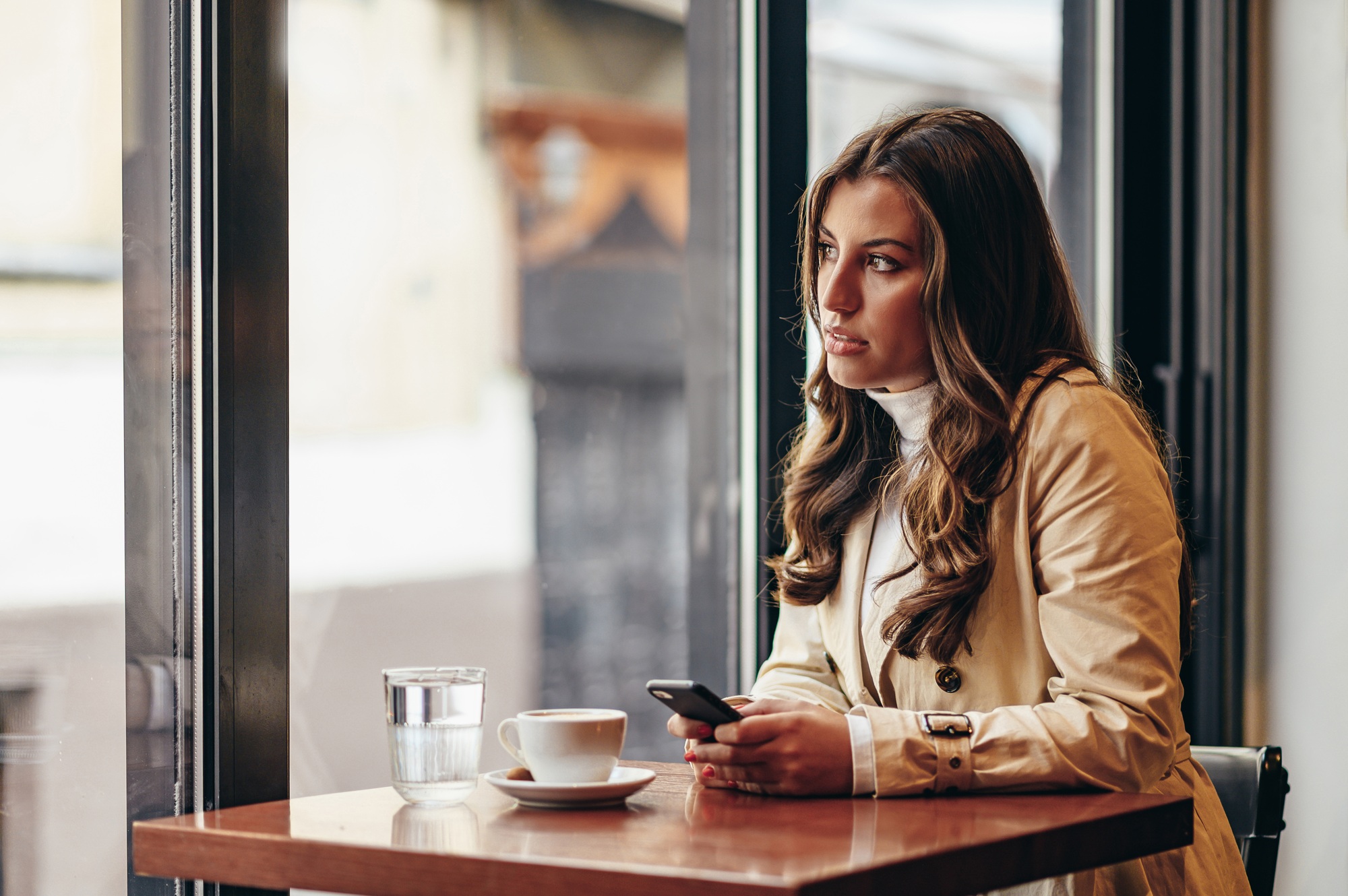 Woman using a smartphone while sitting in a coffee shop