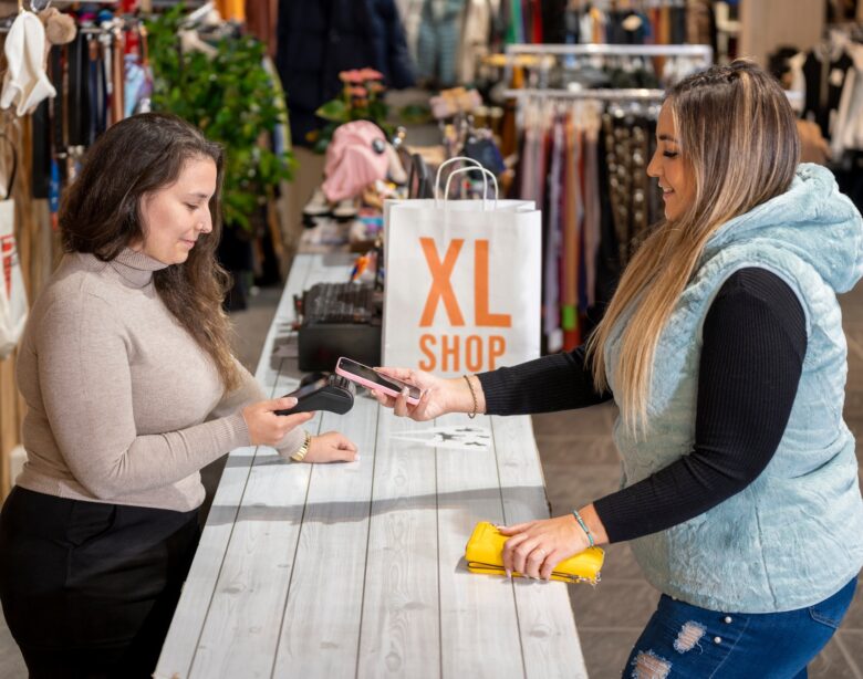 Counter with a customer paying with a smartphone in a plus size clothing store