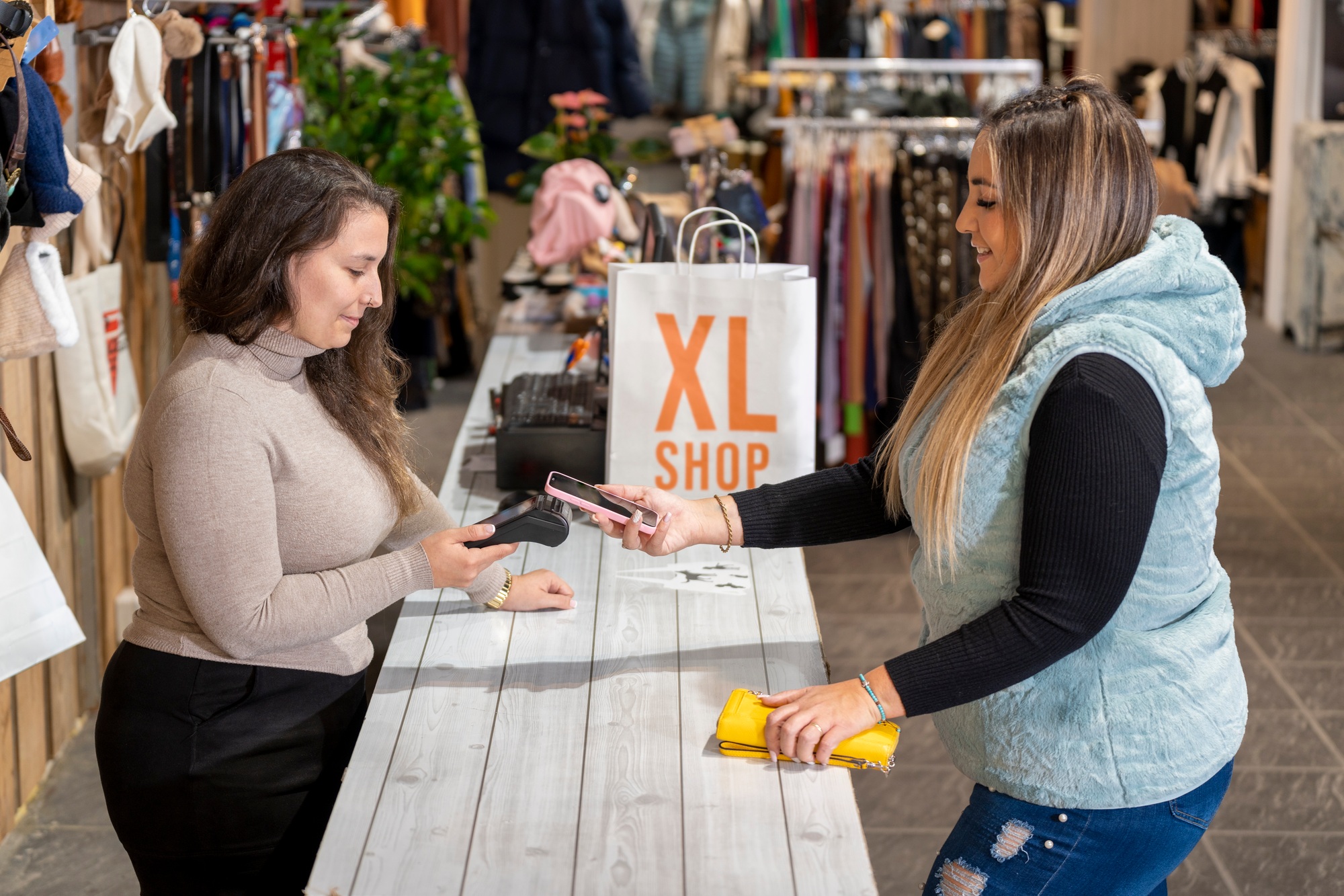 Counter with a customer paying with a smartphone in a plus size clothing store