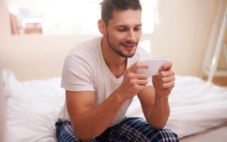 Man texting with friends right after waking up