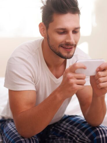 Man texting with friends right after waking up