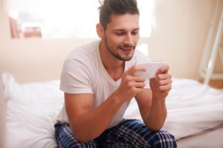 Man texting with friends right after waking up