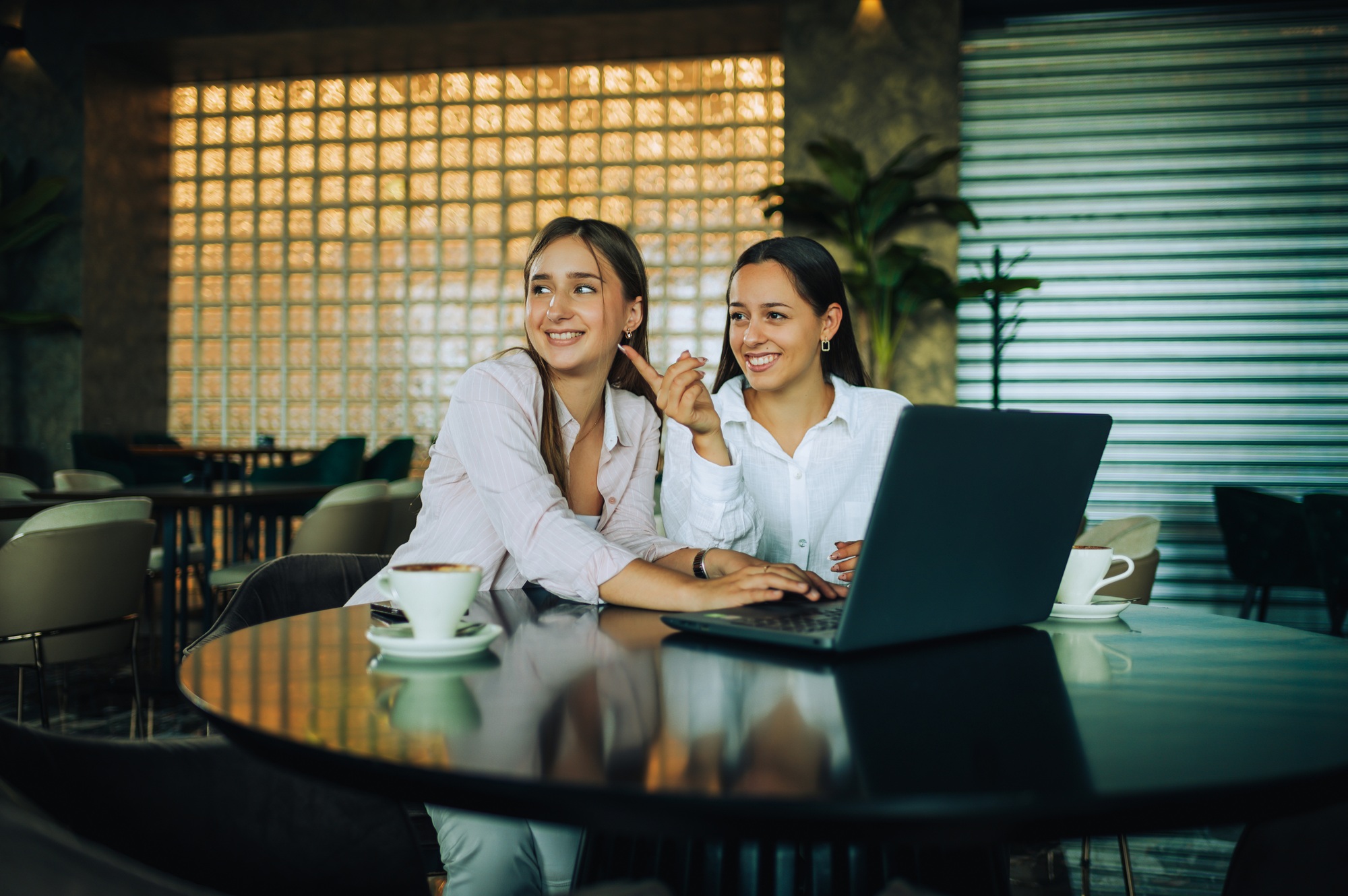 Two besties sitting together in a coffee shop